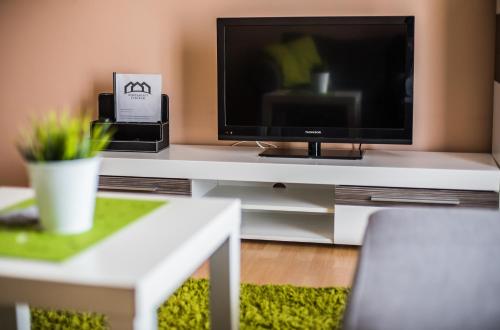 a living room with a television on a white table at Apartament Zwycięstwa in Koszalin