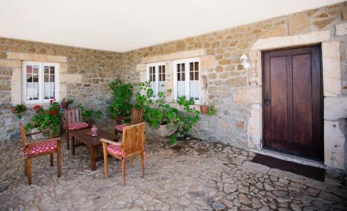a patio with a table and chairs and a wooden door at Quinta da Barroca Douro Valley in Armamar