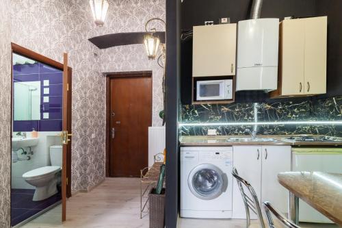 a kitchen with a washing machine and a bathroom at Austrian Apartments Leopolli near railway station in Lviv