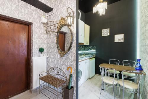 a kitchen with a table and chairs and a mirror at Austrian Apartments in Lviv