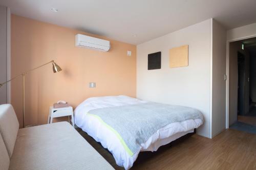a bedroom with a bed and a table and a lamp at Private house Kuranoya Sapporo in Sapporo