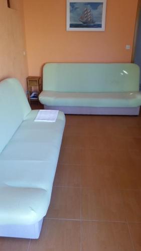 um sofá branco num quarto com piso em azulejo em Apartments Vrisika-family apartment em Makarska