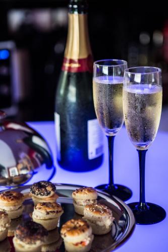 - deux verres de champagne à côté d'une assiette de nourriture dans l'établissement Suite Glamour & Spa, à Dijon