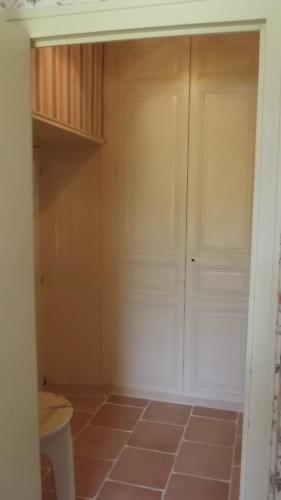 a closet with white doors and a tiled floor at Gite rural DUNAND in Tournon-Saint-Martin