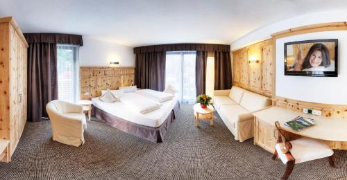 a hotel room with a bed and a couch at Hotel Leitner in Mühlbach