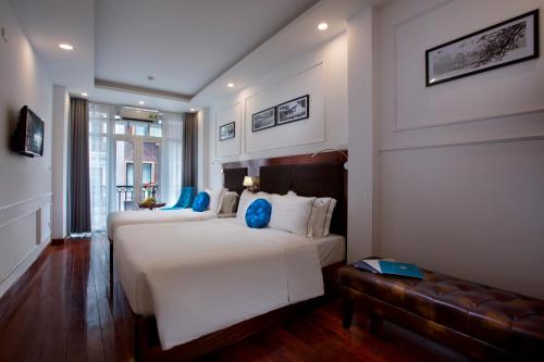 a hotel room with two beds and a couch at Antique Angel Hotel in Hanoi