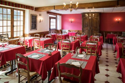 une salle à manger avec des tables et des chaises rouges dans l'établissement Logis Hôtel Restaurant de la Poste, à Le Mêle-sur-Sarthe