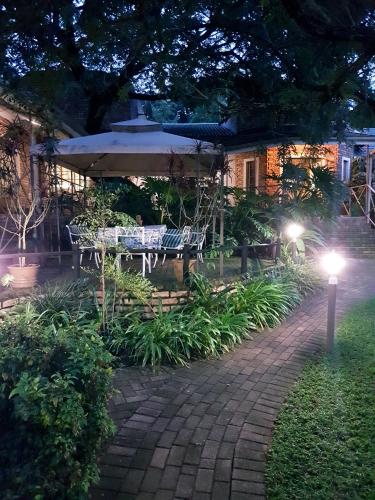 a patio with a table and an umbrella at night at Shingalana Guest Lodge in Hazyview