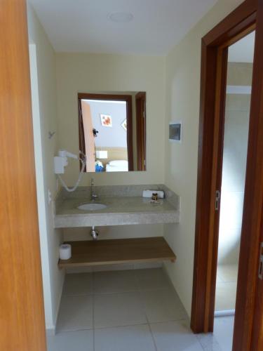 a bathroom with a sink and a mirror at Aldeia das Águas Park Resort - Flat Quartier in Barra do Piraí