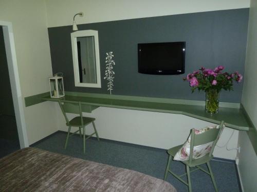 a bedroom with a desk with a tv and flowers at Hotel Flora in Łódź