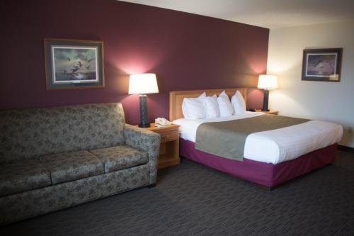 A bed or beds in a room at AmericInn by Wyndham Madison SD