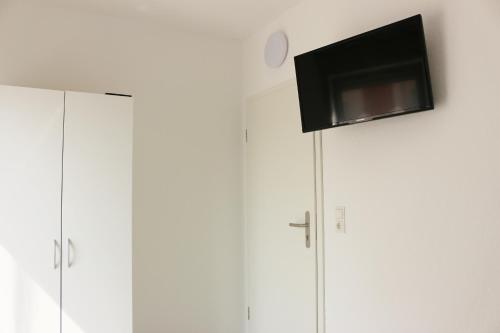 einen Flachbild-TV auf weißen Schränken in der Unterkunft Dornfelder in Hanhofen