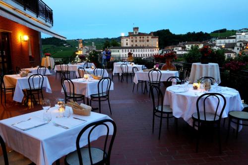 un restaurante con mesas y sillas blancas y vistas en Hotel Barolo Classico, en Barolo