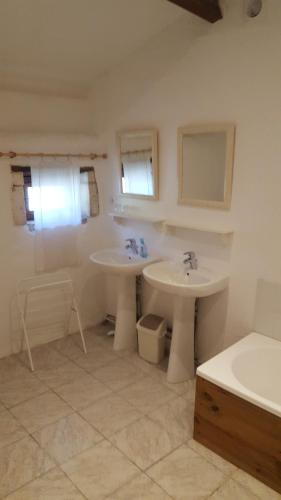 a bathroom with two sinks and two mirrors at Le gîte des chambres de la grange in Cherval