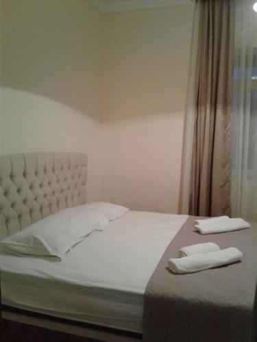 a bed with two white towels on top of it at Gonio Apsaros House in Gonio