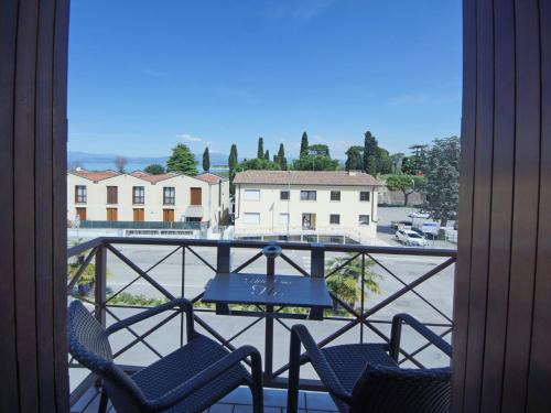 a balcony with chairs and a view of a parking lot at Hotel Dori in Peschiera del Garda
