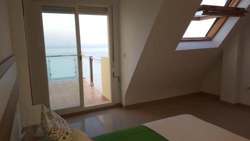 a bedroom with a view of the ocean and a balcony at Duplex Castell de Ferro in Castell de Ferro