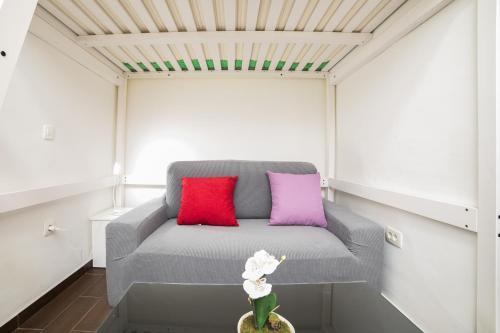 a gray couch with two colorful pillows in a room at Midtown Center Apartments in Zadar