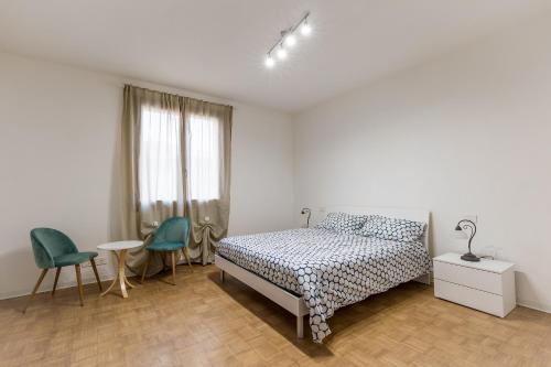1 dormitorio con 1 cama, mesa y sillas en CaMagnolia Apartment, en Montegrotto Terme