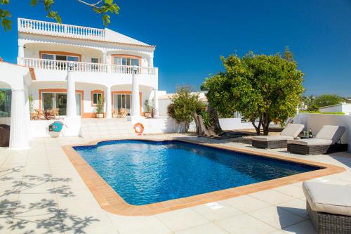 a villa with a swimming pool in front of a house at Casa Luisandra Boutique Hotel B&B in Luz