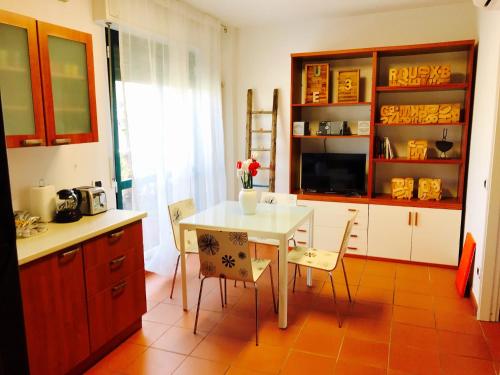 uma cozinha com uma mesa e cadeiras numa cozinha em Camere Delle Rose em Milão