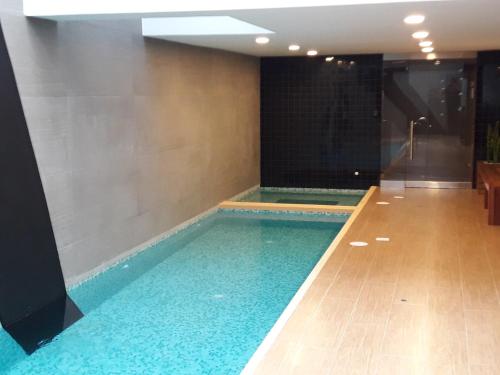 a large swimming pool in a room with a shower at Miraflores Heart Apartment in Lima