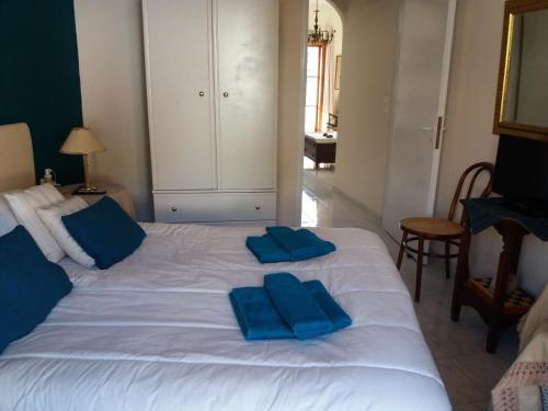 białe łóżko z dwoma niebieskimi poduszkami w obiekcie Forest & Sea Apartment w Poros