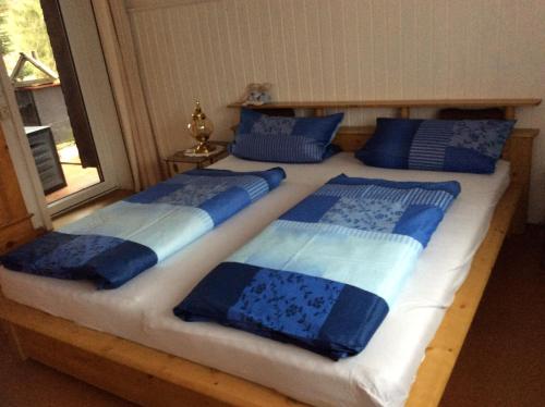 een bed met blauwe en witte dekens en kussens erop bij Haus Seefrieden in Clausthal-Zellerfeld