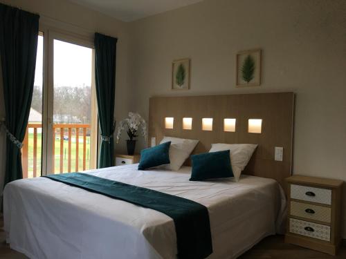 une chambre avec un grand lit avec une grande fenêtre dans l'établissement Au Charme du Lac Espace bien être et Piscine chauffé proche parc et restaurant du casino, à Forges-les-Eaux
