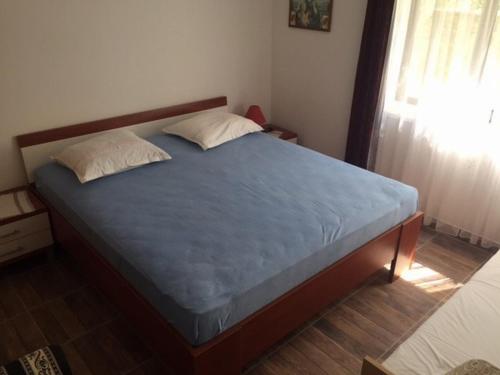 a bedroom with a bed with a blue mattress and a window at Apartments Bili in Starigrad-Paklenica