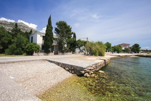 a stone retaining wall next to a body of water at Apartments Bili in Starigrad-Paklenica
