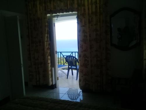 a room with a view of the ocean from a door at Pink Rock Inn Bed and Breakfast in Ocho Rios
