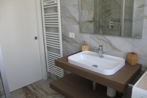 uma casa de banho com um lavatório e um espelho em Domus Helios em Levico Terme