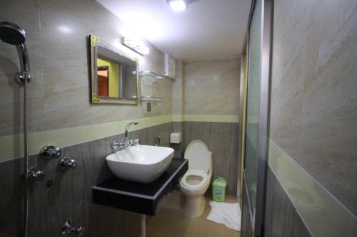 ein Bad mit einem Waschbecken und einem WC in der Unterkunft Little Rangpur Inn in Rangpur