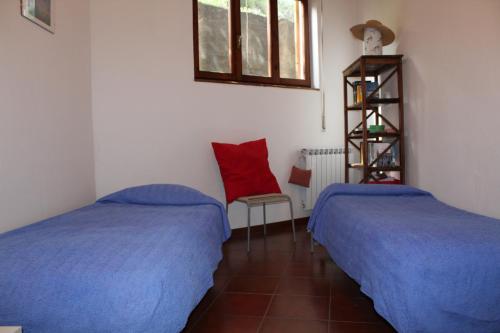 Zimmer mit 2 Betten, einem roten Kissen und einem Regal in der Unterkunft Froggy House in San Lorenzo al Mare