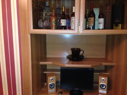 una scrivania con un computer e alcune bottiglie di alcol di Apartment SOFI a Tbilisi City
