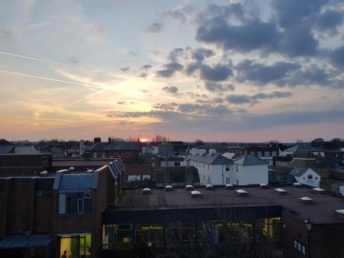 a view of a city with the sunset in the background at Waterfront Hotel in Deal