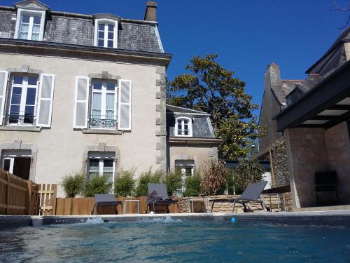 a house with a swimming pool in front of a house at Maison de la Garenne & Spa in Vannes