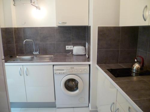 a kitchen with a washing machine and a sink at Karolina Properties - Misericorde Appartements in Cannes