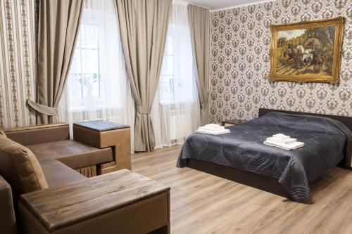 1 dormitorio con 1 cama, 1 silla y 1 sofá en Art house Hostel en Kamianets-Podilskyi