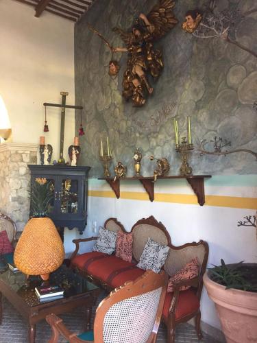 a living room with two chairs and a couch and a table at Hotel San Miguel Arcangel in Izamal