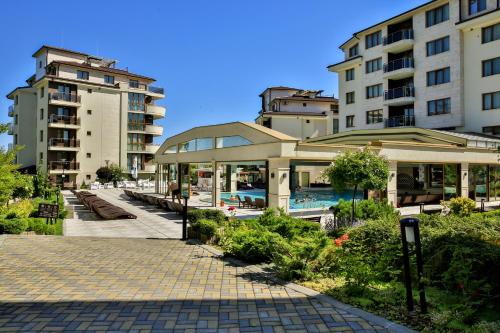 a resort with a swimming pool and two buildings at Al Rial Beach Apartments in Shkorpilovtsi