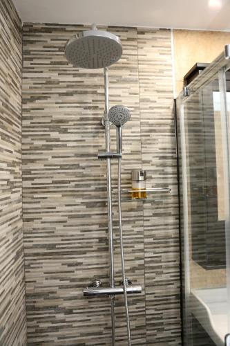 eine Dusche in einem Badezimmer mit einer Steinwand in der Unterkunft Avenida de la Cornisa 11 in Puerto Rico de Gran Canaria