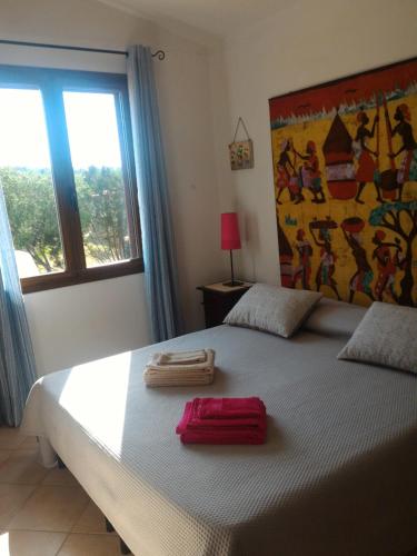 a bedroom with a bed with two towels on it at Casa di Rosa in Chia