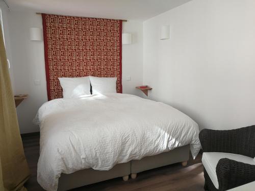 a bedroom with a white bed with a red headboard at Un jardin sur le toit - Saintes in Saintes