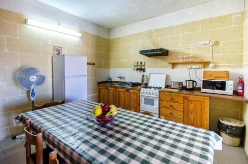 eine Küche mit einem Tisch und einer Obstschale darauf in der Unterkunft Kaccatur Flats in Marsalforn