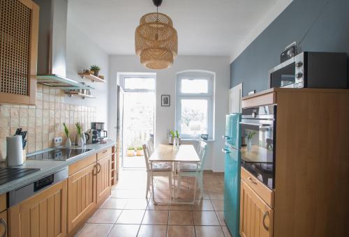 eine Küche mit einem Tisch und einem blauen Kühlschrank in der Unterkunft Stadtbleibe Naumburg in Naumburg