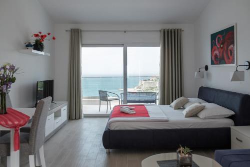 sypialnia z łóżkiem i widokiem na ocean w obiekcie Sunset Apartments w Ulcinju
