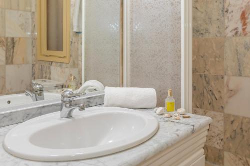 a bathroom with a white sink and a shower at Apartament Cap de Vol in Port de la Selva