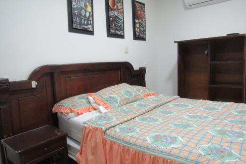 a bedroom with a bed with an orange and blue quilt at Hotel Nuevo Tio in Valledupar